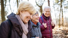 Drei Senioren wandern lachend