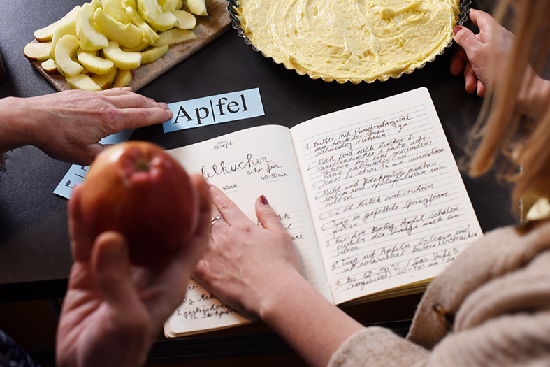 Person lernt Übersetzung mit Apfel in der Hand